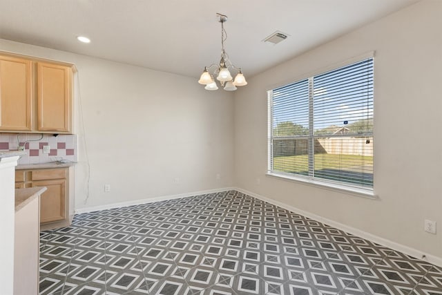 unfurnished dining area featuring an inviting chandelier