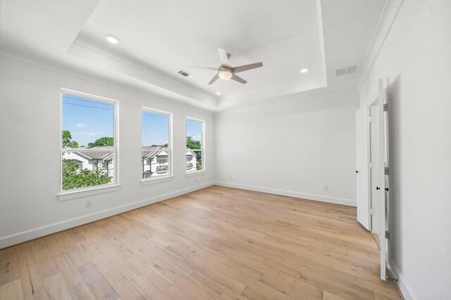 spare room featuring ceiling fan, a raised ceiling, and light hardwood / wood-style flooring