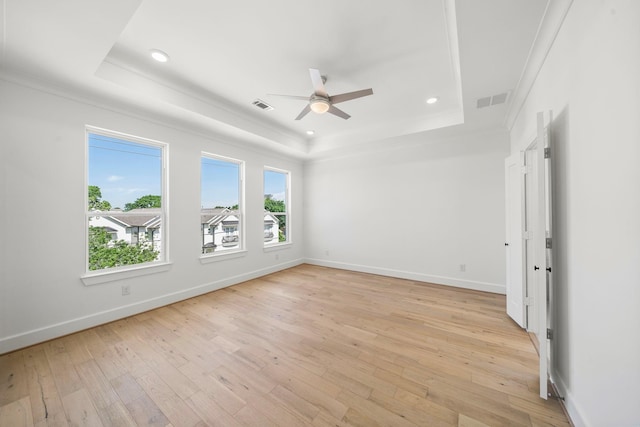 unfurnished room featuring ornamental molding, a raised ceiling, ceiling fan, and light wood-type flooring