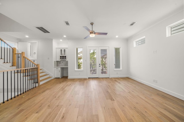 unfurnished living room featuring french doors, light wood-type flooring, ceiling fan, and crown molding