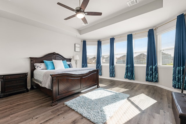 bedroom with ceiling fan, hardwood / wood-style flooring, and a raised ceiling