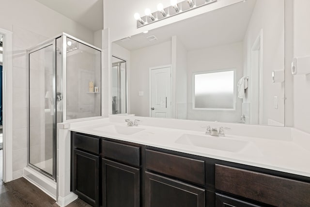 bathroom with walk in shower, vanity, and hardwood / wood-style flooring