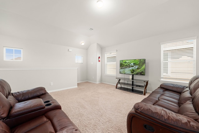 carpeted living room with a healthy amount of sunlight and vaulted ceiling