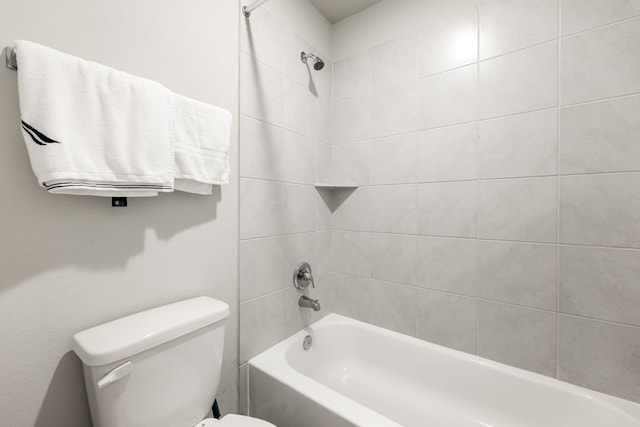 bathroom with toilet and tiled shower / bath combo