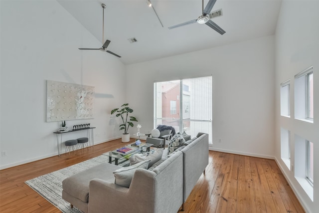 living room featuring ceiling fan, high vaulted ceiling, and light hardwood / wood-style floors