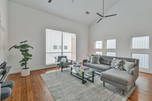 living room with ceiling fan, high vaulted ceiling, and light wood-type flooring