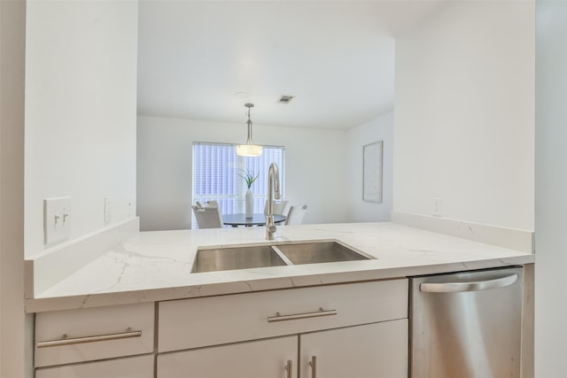 kitchen featuring dishwasher, decorative light fixtures, light stone counters, and sink