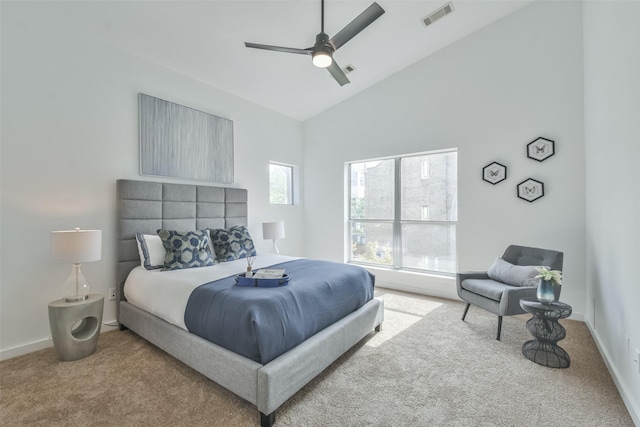 carpeted bedroom with ceiling fan and high vaulted ceiling