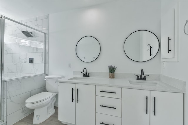 bathroom featuring vanity, toilet, and a shower with door