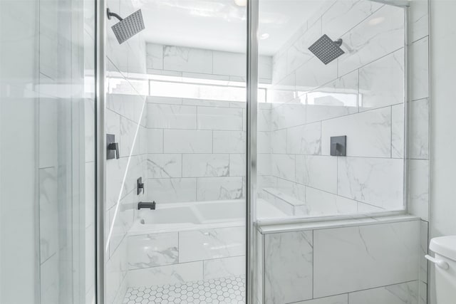 bathroom with toilet and combined bath / shower with glass door