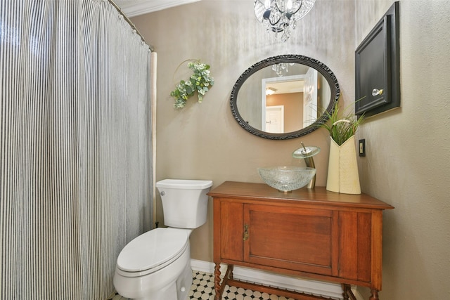 bathroom featuring vanity, toilet, a notable chandelier, and crown molding