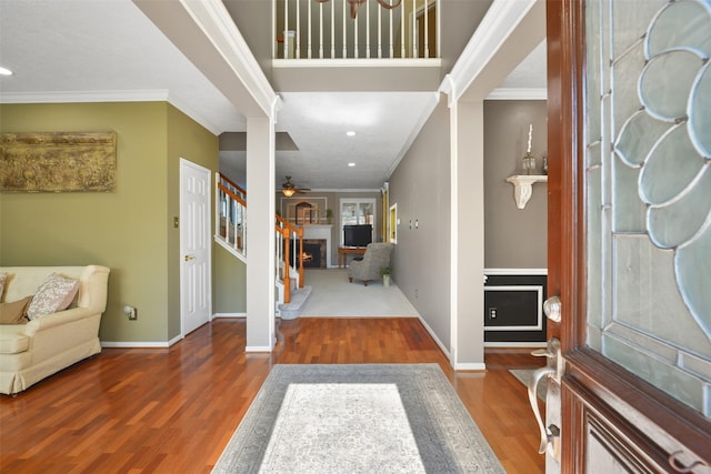 foyer entrance with ceiling fan, crown molding, and dark wood-type flooring