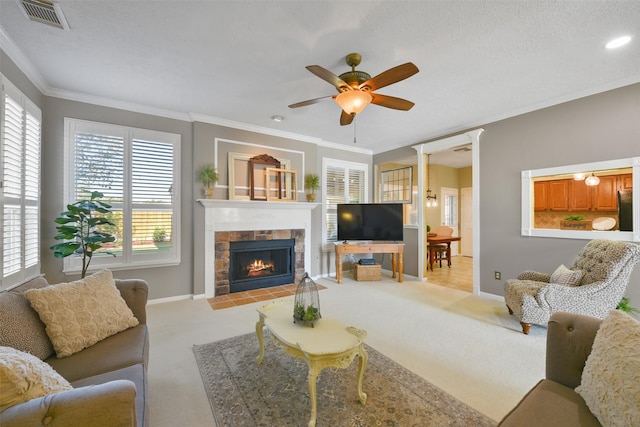 living room featuring a textured ceiling, ceiling fan, ornamental molding, and light carpet