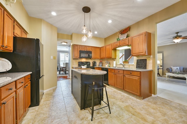 kitchen with pendant lighting, a breakfast bar, a center island, black appliances, and tasteful backsplash