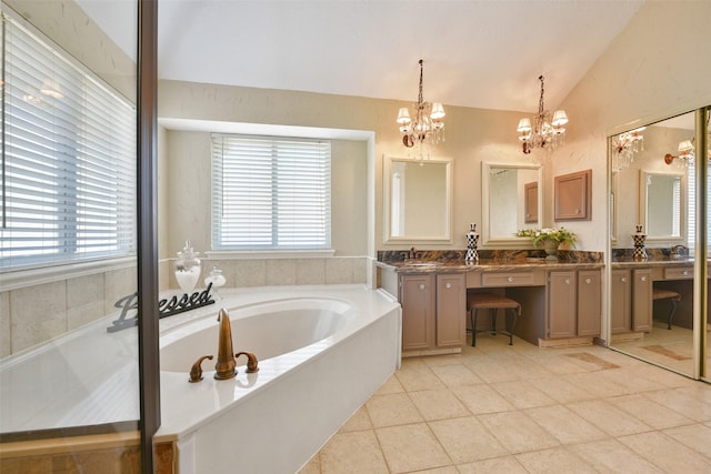 bathroom featuring vanity, an inviting chandelier, vaulted ceiling, tile patterned flooring, and tiled tub