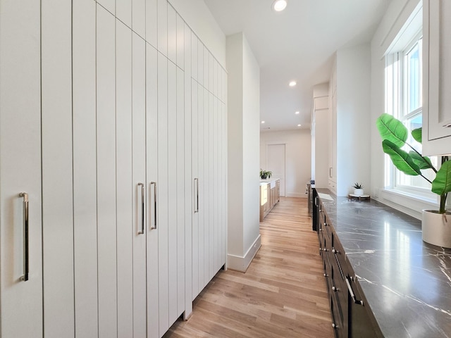 corridor with light hardwood / wood-style flooring