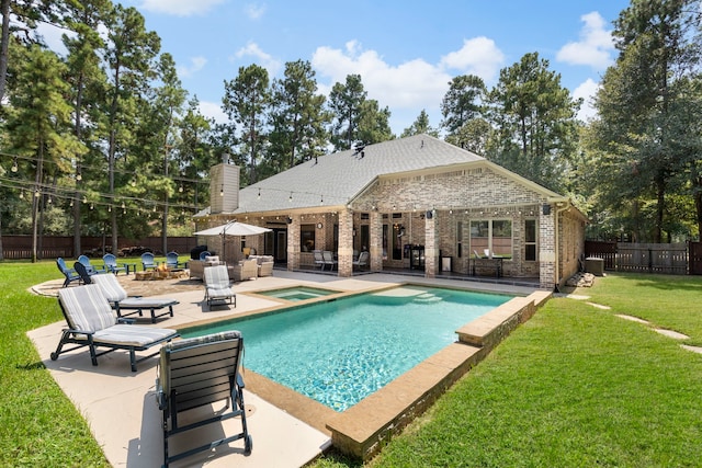 view of swimming pool with a lawn, a patio area, and an in ground hot tub