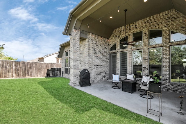 view of patio with grilling area, ceiling fan, and a fire pit