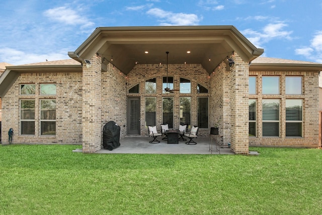 rear view of property with a yard and a patio area