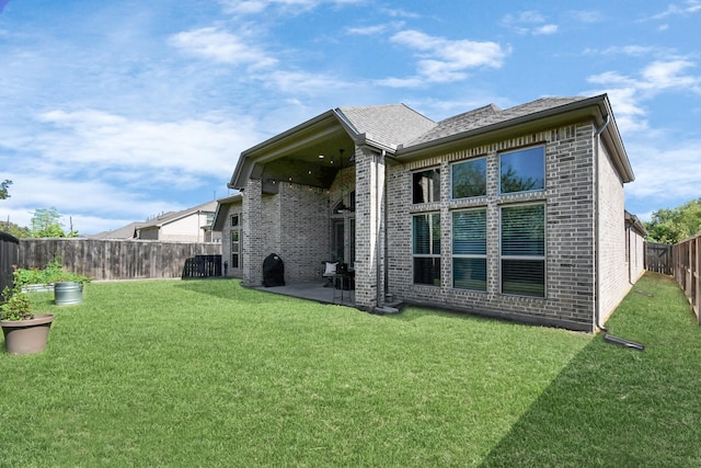 rear view of house with a lawn and a patio