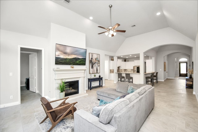 living room featuring ceiling fan and high vaulted ceiling