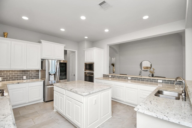 kitchen with sink, stainless steel appliances, kitchen peninsula, decorative backsplash, and a kitchen island