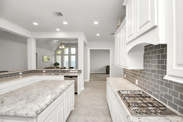 kitchen featuring appliances with stainless steel finishes, white cabinetry, and light stone counters