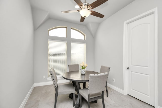 tiled dining room with ceiling fan and lofted ceiling