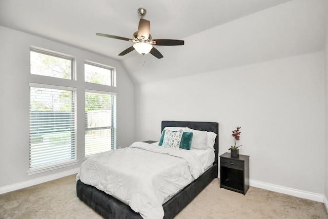 bedroom featuring light carpet, multiple windows, vaulted ceiling, and ceiling fan