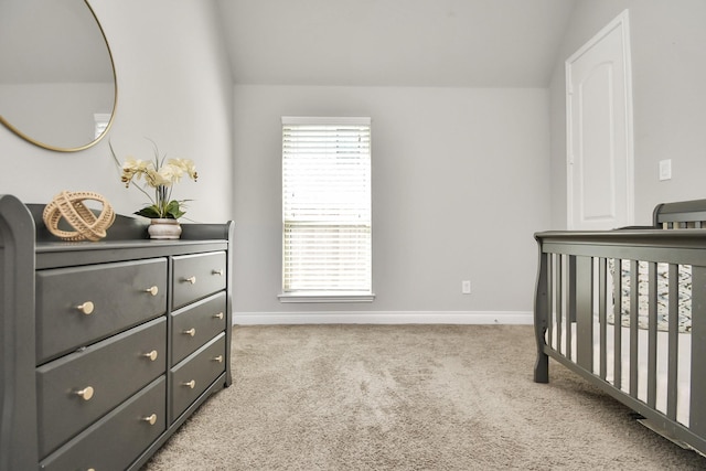 carpeted bedroom with a nursery area and lofted ceiling