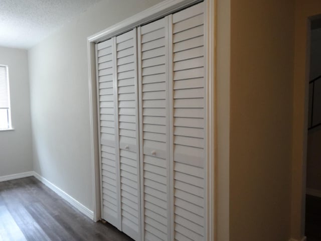 room details featuring baseboards, wood finished floors, and a textured ceiling