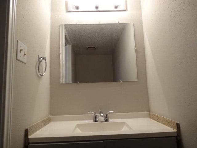 bathroom with a textured ceiling and vanity