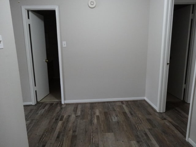 empty room featuring baseboards and wood finished floors