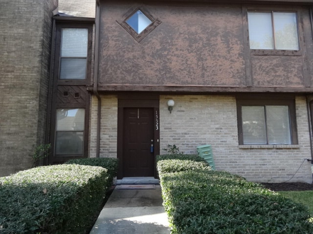 doorway to property featuring brick siding