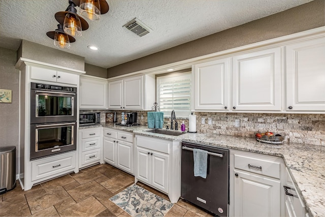 kitchen featuring light stone counters, a textured ceiling, stainless steel appliances, sink, and white cabinetry