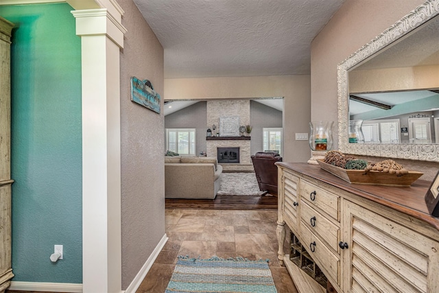 hallway with a textured ceiling and vaulted ceiling