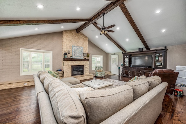 living room featuring ceiling fan, a fireplace, lofted ceiling with beams, and dark hardwood / wood-style floors