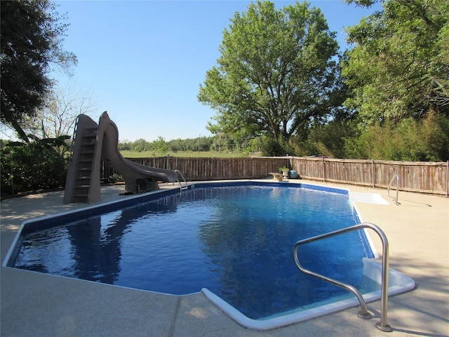 view of swimming pool with a patio area and a water slide