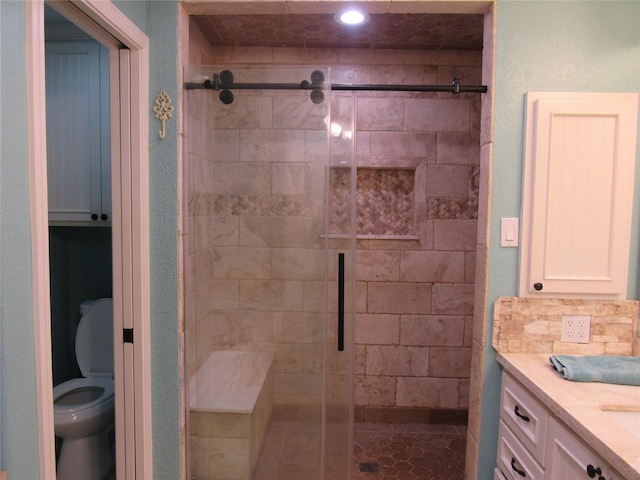 bathroom featuring vanity, toilet, backsplash, and walk in shower