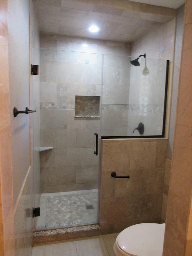 bathroom featuring toilet and an enclosed shower