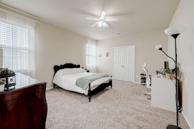 bedroom featuring ceiling fan, a closet, carpet floors, and multiple windows