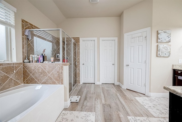 bathroom with separate shower and tub, vanity, and hardwood / wood-style flooring