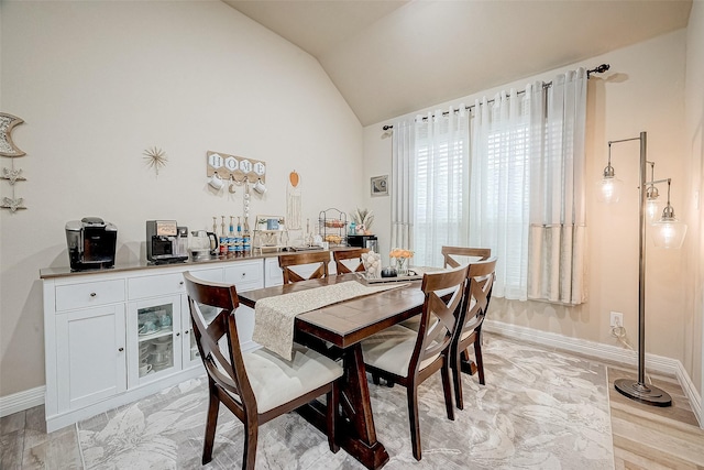 dining area featuring lofted ceiling and light hardwood / wood-style flooring