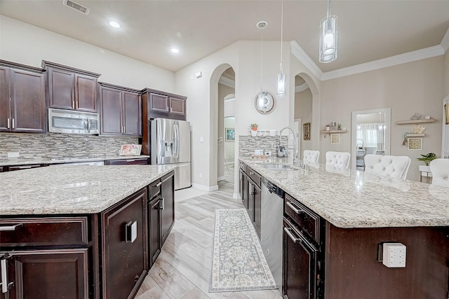 kitchen featuring backsplash, a kitchen island, sink, and appliances with stainless steel finishes