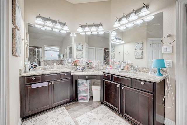 bathroom featuring hardwood / wood-style floors, vanity, and a shower with door