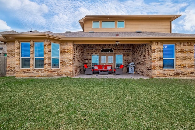 rear view of house featuring a patio area, outdoor lounge area, a lawn, and brick siding