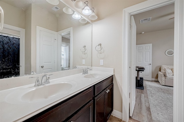 bathroom with double vanity, a sink, and visible vents