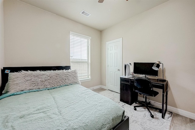 bedroom with light wood-type flooring, baseboards, visible vents, and a ceiling fan