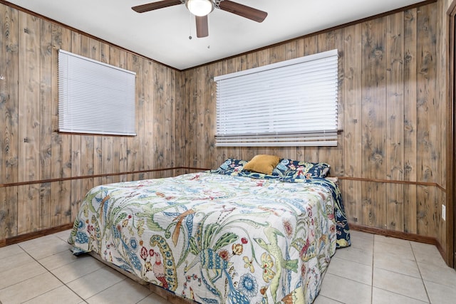 bedroom featuring light tile patterned floors, ceiling fan, and wooden walls