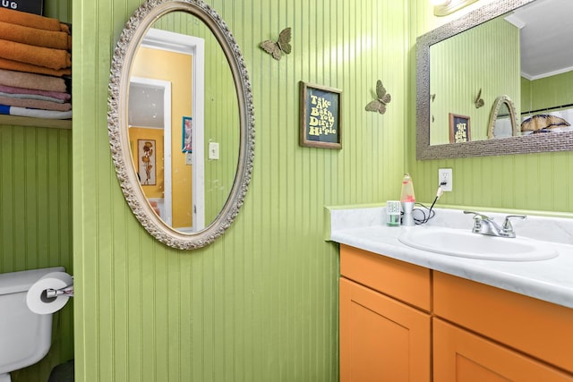 bathroom with vanity, toilet, and ornamental molding